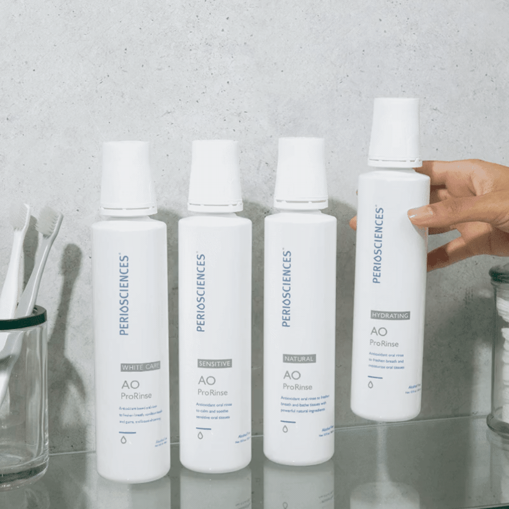 PerioSciences AO ProRinse Hydrating Mouthwash displayed alongside White Care, Sensitive, and Natural variants on a bathroom shelf